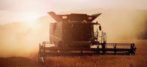 Tractor threshing a field