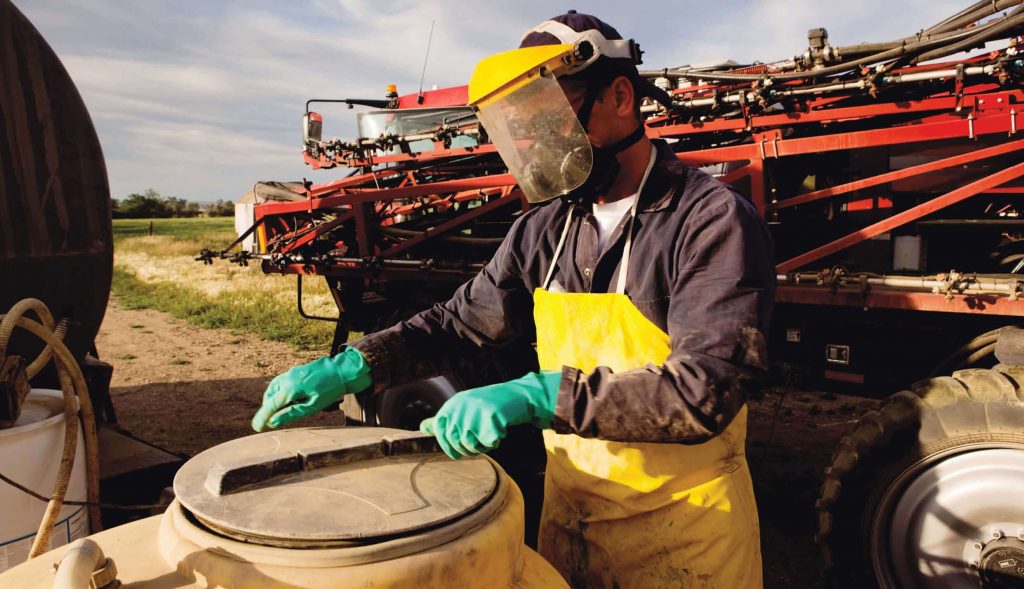 Man handling chemicals with safety equipment on